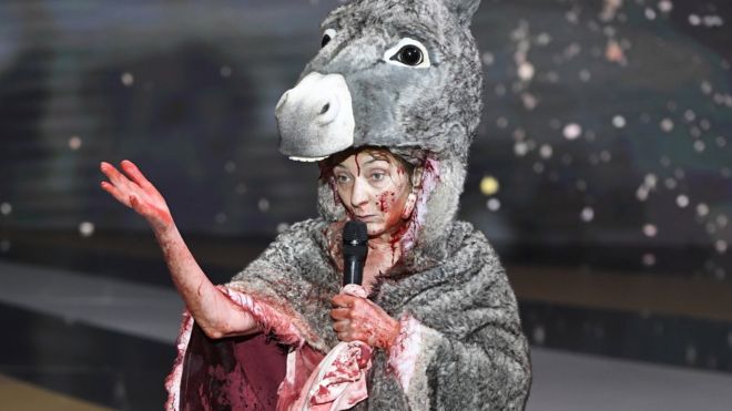 French actress Corinne Masiero (left) wears a donkey costume on top of a bloodied dress in Paris, France. Photo: 12 March 2021