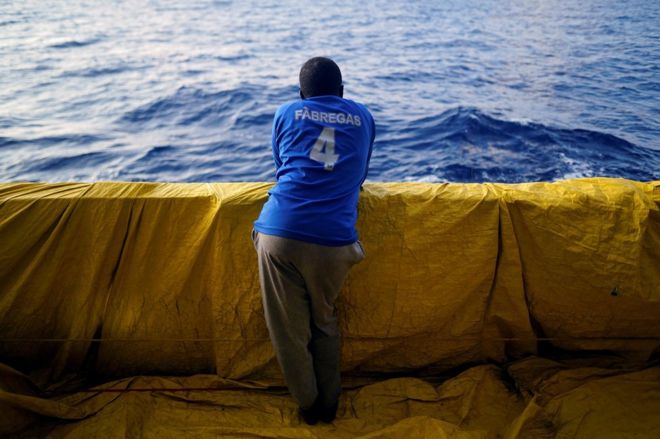 Юсеф, 28 лет, из Судана, стоит на борту спасательной лодки НПО Proactiva Open Arms в центральной части Средиземного моря