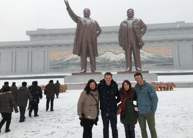 Отто Вармбиер и его друзья позируют перед статуями в Северной Корее