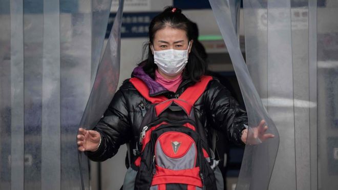Woman wearing a protective facemask at the Beijing railway station