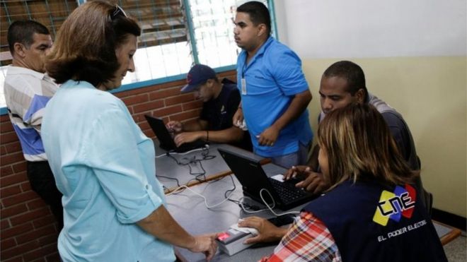 Женщина проверяет свою личность во время второго этапа Венесуэлы в Национальном избирательном совете (CNE) по проверке подписей для референдума об отзыве президента Николаса Мадуро в Каракасе, Венесуэла, 20 июня 2016 года.