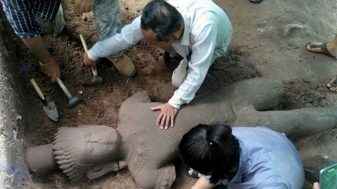 Археологи занимаются раскопками статуи из песчаника в храмовом комплексе Ангкор-Ват в провинции Сиемреап (1 августа 2017 года)