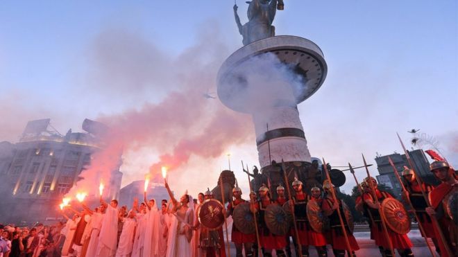 Македонцы в костюмах стоят перед памятником Воину на коне высотой 14,5 метра на постаменте высотой 10 метров, который официально открыт в центре Скопье, столицы Республики Македонии, 8 сентября 2011 года