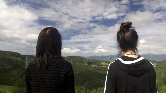 Now safely over the border Mira (L) and Jiyun (R) look out over a mountain range back towards China