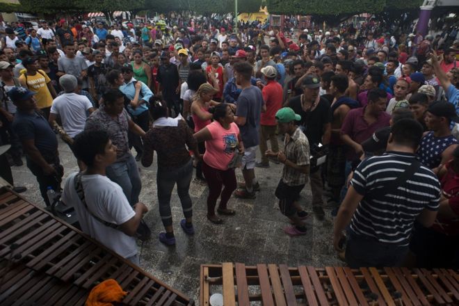 Мигранты танцуют местные музыканты играют музыку на центральной площади Сьюдад-де-Идальго