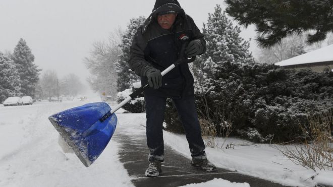 Мужчина убирает снег в Денвере