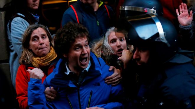 Каталонские демонстранты, выступающие за независимость, протестуют против визита испанского короля Филиппа VI на Всемирном конгрессе мобильных телефонов (MWC) перед каталонскими региональными полицейскими Моссос д'Эсквадра 25 февраля 2018 года в Барселоне