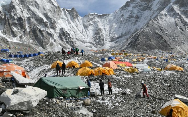 Треккеры и носильщики собираются в базовом лагере Эвереста 25 апреля 2018 года.