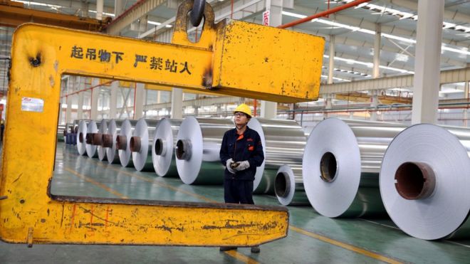 На этой фотографии, сделанной 20 мая 2017 года, изображен китайский рабочий, загружающий алюминиевые ленты на заводе по производству алюминия в Хуайбэй, провинция Аньхой в восточном Китае
