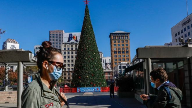 People walk through a quiet Union Square, past a Christmas tree, in San Francisco, California on 1 December 2020