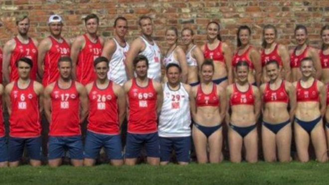 The male and female Norwegian teams pose side by side, the men wearing shorts and long tank tops, the women wearing small bikini tops and bottoms.