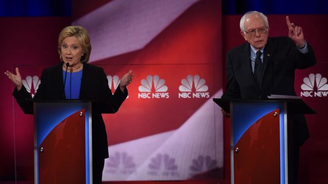 Кандидаты в президенты от Демократической партии, бывший госсекретарь Хиллари Клинтон (слева) и сенатор Вермонта Берни Сандерс (справа) принимают участие в дебатах кандидатов в президенты NBC News - YouTube 17 января 2016 г.