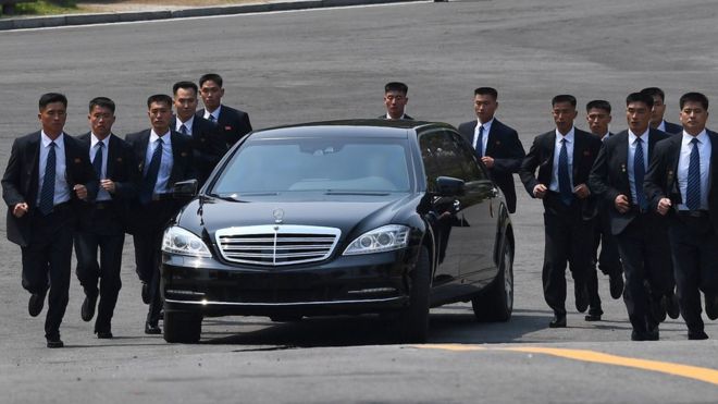 Телохранители бегут рядом с машиной с северокорейским лидером Ким Чен Ыном, когда он возвращается на север на обеденный перерыв после утренней сессии межкорейского саммита в Панмунжоме, 27 апреля 2018 года