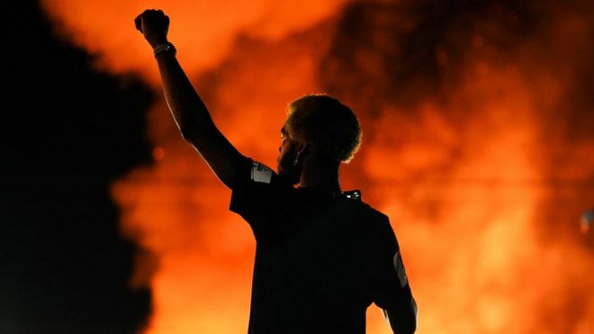 A protester watches as a Wendy's restaurant burns in Atlanta