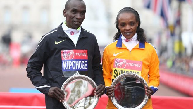 Кенийцы Элиуд Кипчоге (слева) и Джемима Сумгонг позируют после победы на Лондонском марафоне 2016 года - 24 апреля 2016 года