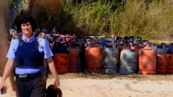 Policial espanhol ao lado de bujões de gás em Alcanar