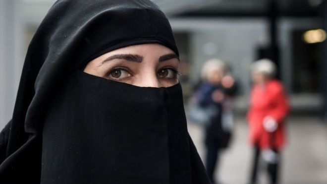 A woman wearing a niqab looks on during a protest by a French-Algerian businessman and political activist, on October 3, 2018 in St. Gallen by following a massive vote in the Swiss northeastern canton of St. Gallen to prohibit all face-covering garments in public spaces.