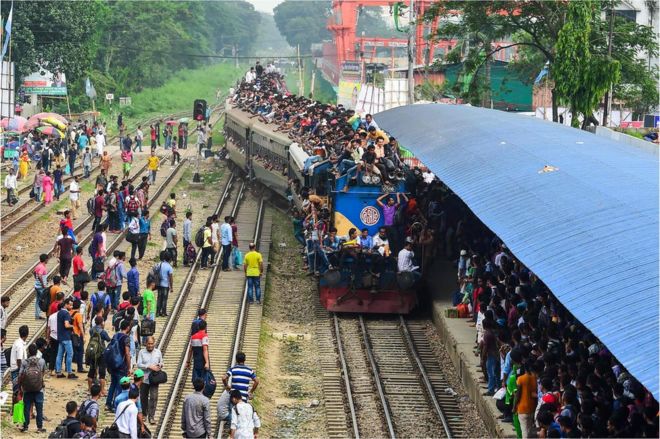 Бангладешцы забираются в поезд, когда они возвращаются домой, чтобы быть со своими семьями перед мусульманским праздником Ид аль-Фитр в Дакке 14 июня 2018 года