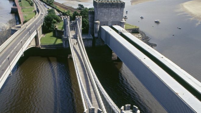 Аэрофотоснимок, показывающий три моста через мутную реку Конви, слева - автомобильный мост