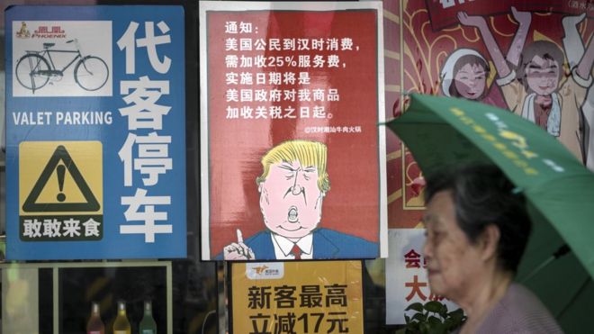 Женщина проходит мимо ресторана с плакатом с изображением президента США Дональда Дж. Трампа, в котором говорится, что в Гуанчжоу, провинция Гуандун, Китай, 13 августа 2018 года.