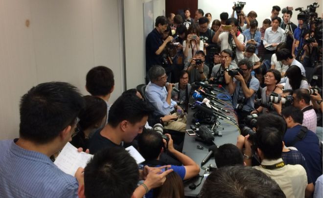 Бывший в тюрьме издатель Lam Wing Kee в окружении журналистов на пресс-конференции в Гонконге - 16 июня 2016 года