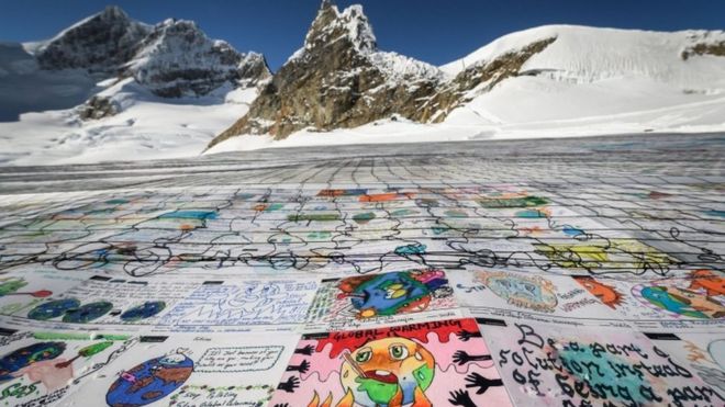 An aerial view shows a massive collage of drawings about climate change rolled out on the Aletsch Glacier in the Swiss Alps