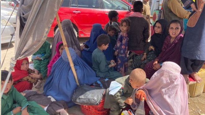 더위와 기다림에 지친 아프간 여성과 아이들
