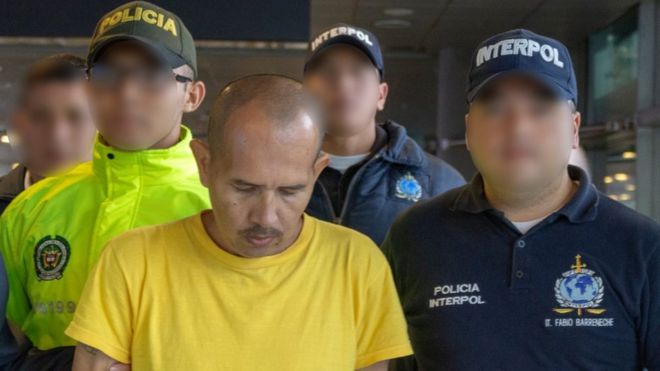 Homem conhecido como 'Lobo Mau' escoltado por policiais. Ele foi condenado a 60 anos de prisão por cometer abusos sexuais contra quase 300 crianças e adolescentes na Colômbia