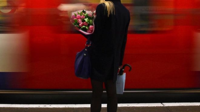 Una mujer espera al tren tras el trabajo.