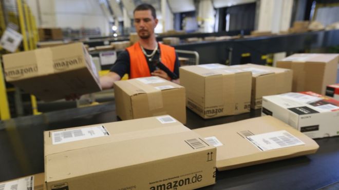 Работник готовит посылки для доставки на склад Amazon 4 сентября 2014 года в Бризеланге, Германия.