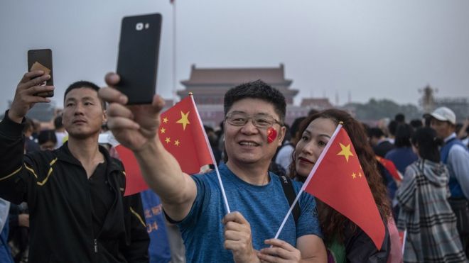 Два человека делают селфи на площади Тяньаньмэнь