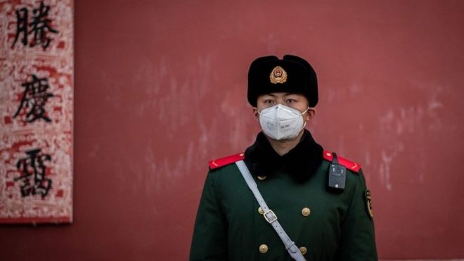 Офицер полувоенной полиции стоит на страже у выхода из Запретного города в Пекине