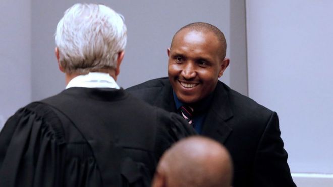 Бывший конголезский военачальник Боско Нтаганда (справа) приветствует своего адвоката Стефана Бургона (слева) в зале суда Международного уголовного суда (МУС) во время заключительных заявлений о своем судебном процессе в Гааге, Нидерланды, 28 августа 2018 года.