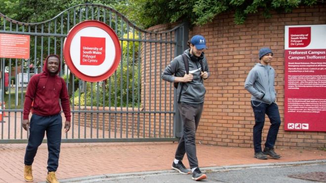 Студенты социально дистанцируются, покидая кампус Университета Южного Уэльса в Трефоресте