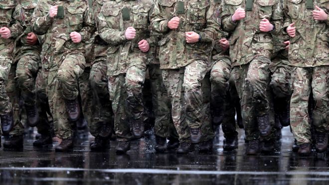 Британские солдаты маршируют под дождем