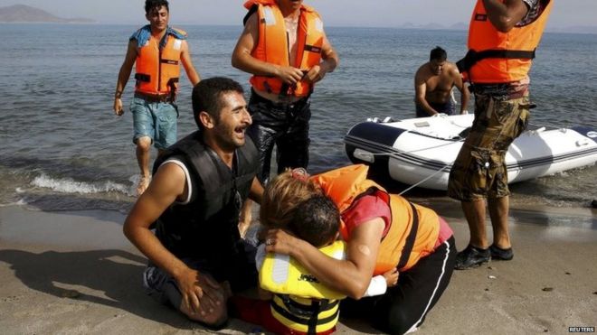Иранский мигрант плачет рядом со своим сыном и женой через несколько минут после прибытия на пляж Кос в маленькой истощенной группе, которая катается на лодке из Турции 15/08/2015