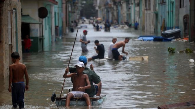10 сентября 2017 года кубинцы пробираются по затопленной улице в Гаване.
