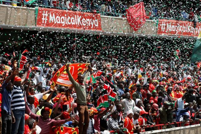 Люди празднуют, как Ухуру Кеньятта принимает присягу на церемонии приведения к присяге на стадионе Касарани в Найроби, Кения, 28 ноября