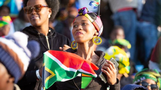 Женщины машут южноафриканским флагом