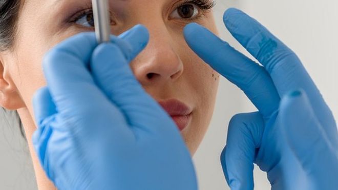 Woman having her nose examined