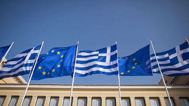 Государственный флаг Греции и флаг Европейского союза развеваются над правительственным зданием.