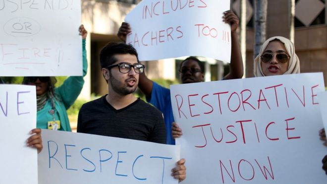 Мухаммад Насим Ул Гани (слева) и Надин Али объединяются с другими протестующими перед административным зданием школы округа Бровард, требуя от учителя, обвиняемого в использовании этнического оскорбления, против ученика-мусульманина 11 марта 2015 года в Форт-Лодердейле, штат Флорида.