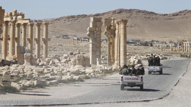 Syrian army forces pass the Arch of Triumph in Palmyra in April