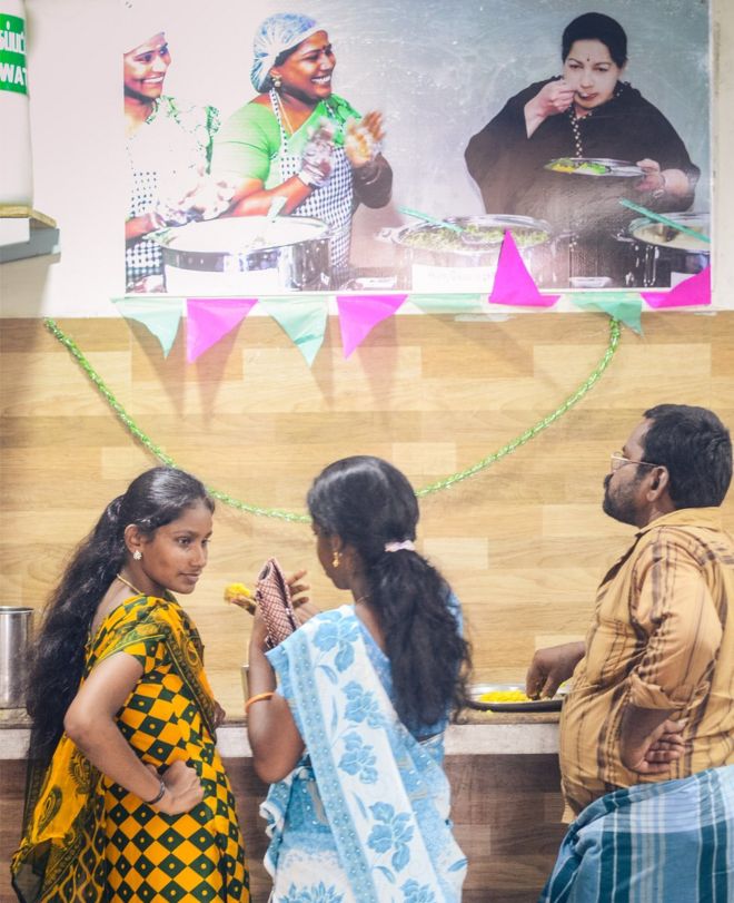 Обедающие под плакатом Jayalalithaa