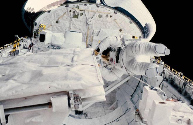 Астронавт Кэтрин Д. Салливан проверяет защелку антенны SIR-B в открытом грузовом отсеке космического челнока «Челленджер» во время его исторического выхода в открытый космос 11 октября 1984 г.