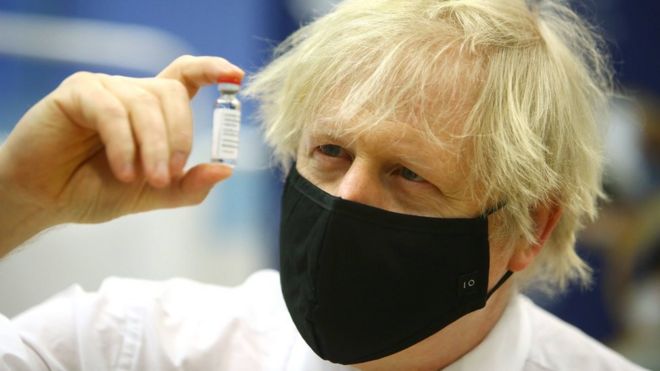 Prime minister Boris Johnson holding a vial of the Oxford/Astra Zeneca Covid-19 vaccine as he visits a vaccination centre at Cwmbran Stadium in Cwmbran, south Wales