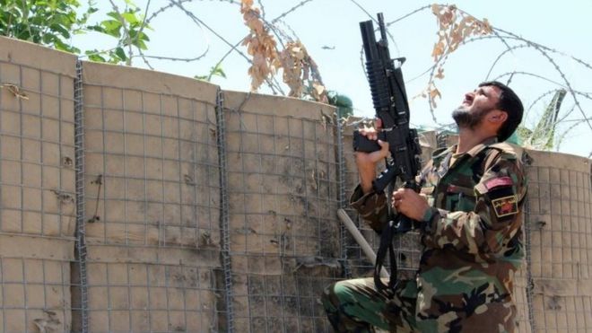 Сотрудник афганских сил безопасности занимает позицию во время операции против боевиков движения «Талибан» в районе Над Али в провинции Гильменд (27 апреля 2016 года)