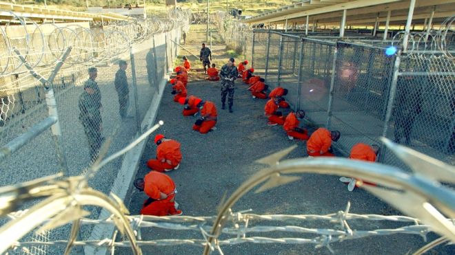 US Military Police guard Taliban and al-Qaeda detainees in orange jumpsuits January 11, 2002