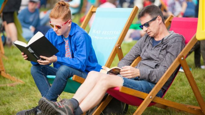 Два человека читают на фестивале сена
