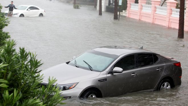 Частично затопленные автомобили соскользнули с обочины на Ист-Бэттери-стрит, когда штормовой нагон и дождевая вода от урагана Мэтью затопили самую южную оконечность города Чарлстон, Южная Каролина, 8 октября 2016 года.